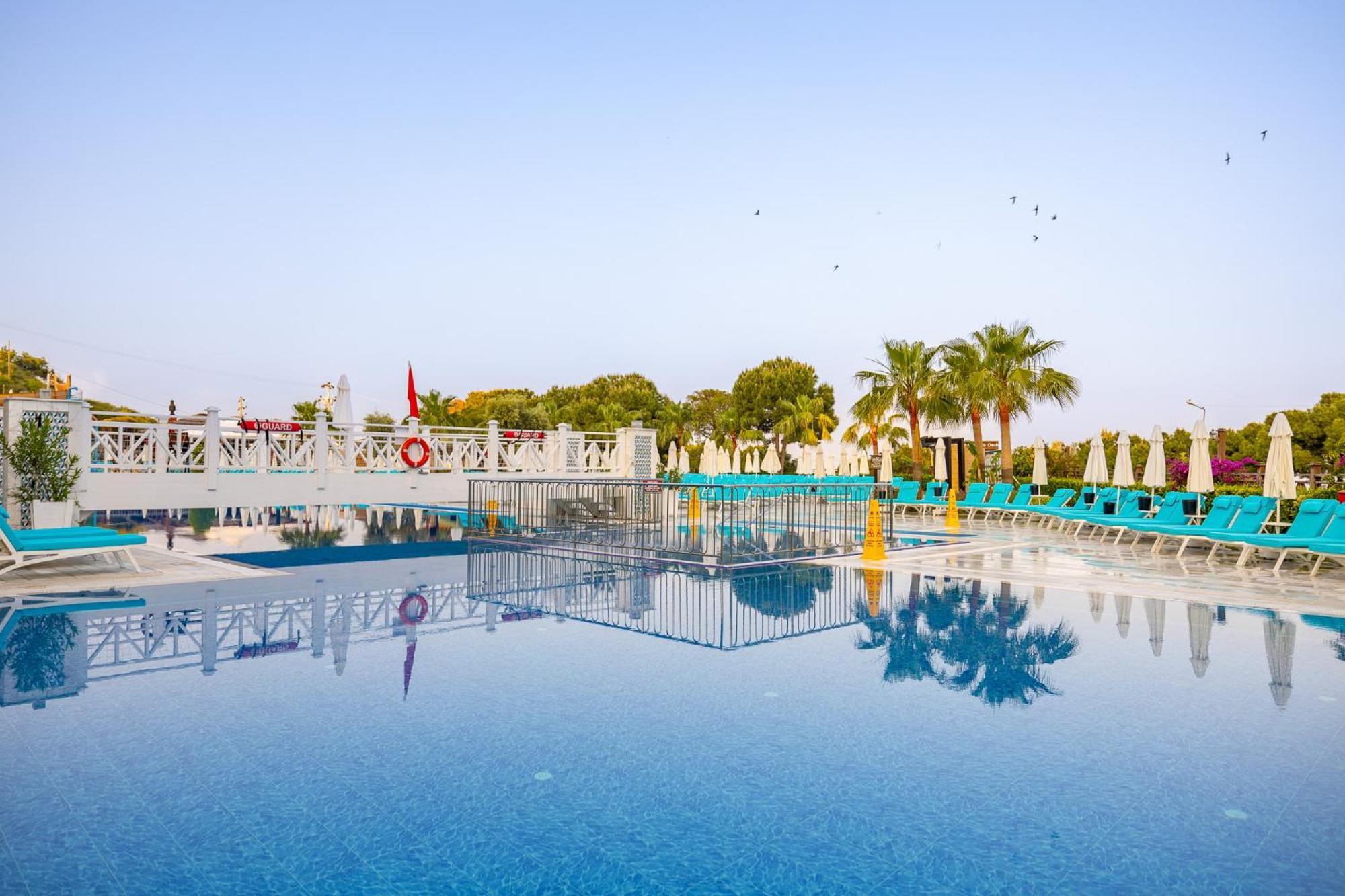 Ramada Resort Kusadasi & Golf Kültér fotó A swimming pool at a hotel in Turkey